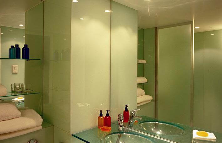 two mirrored walls and green splashbacks in bathroom