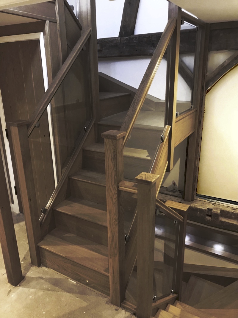 dark wooden staircase with glass side panels