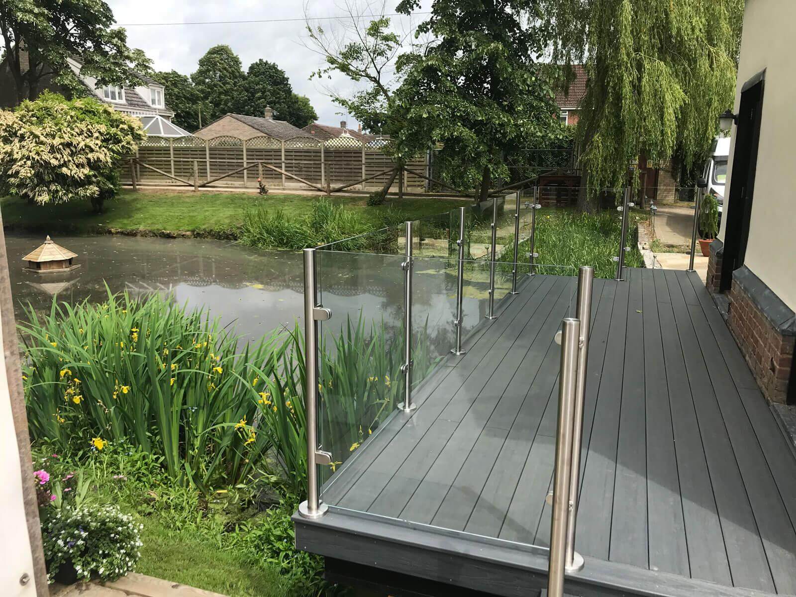 glass balustrade for decking overlooking the pond in the back garden