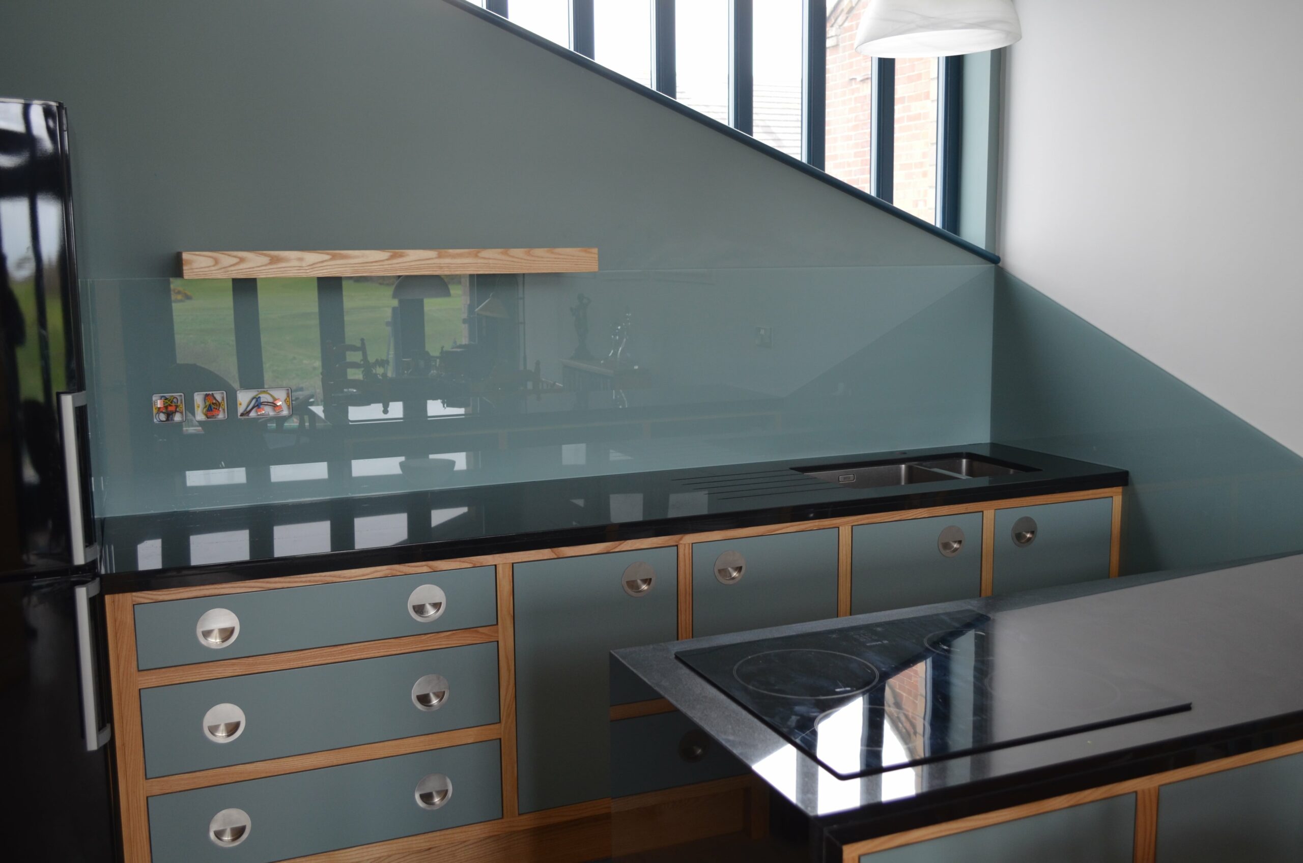 small kitchen with duck egg blue splashback and glass wall panels