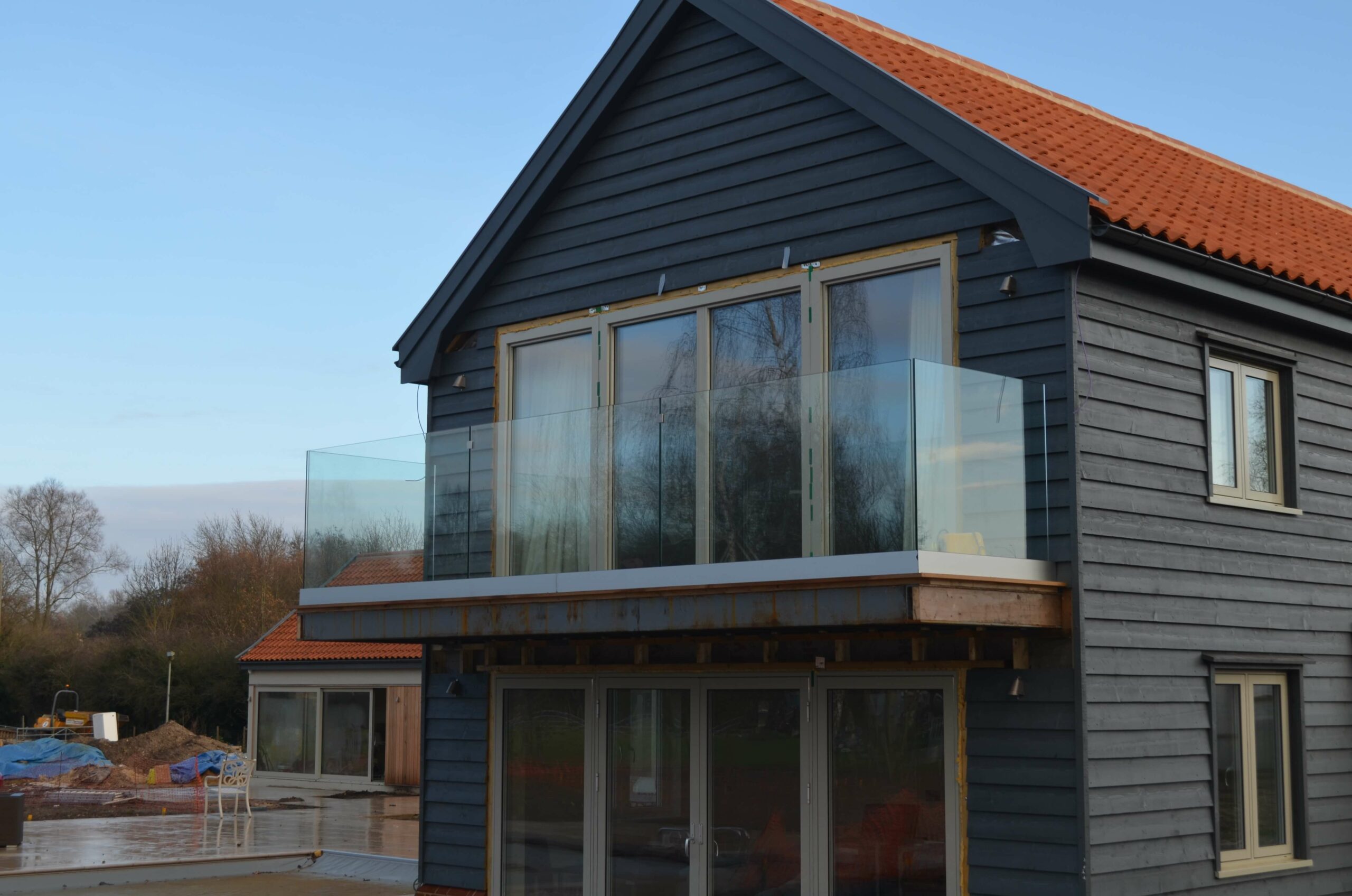 black wooden house with cantilever balcony