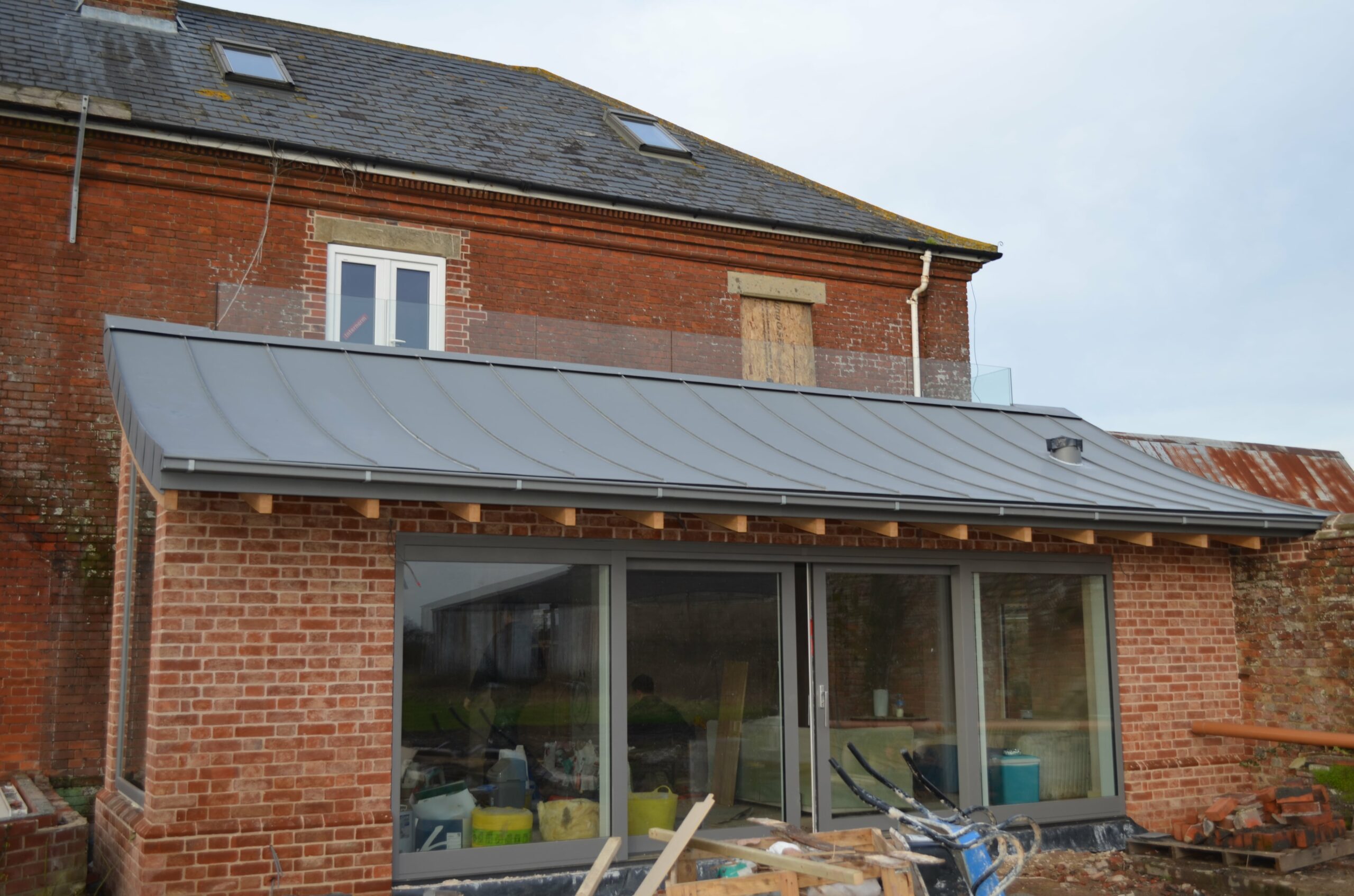 walk on balcony installed above conservatory extension on back of house