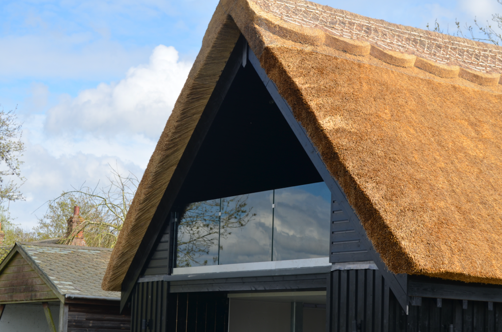 thatched roof house with stunning frameless glass balcony