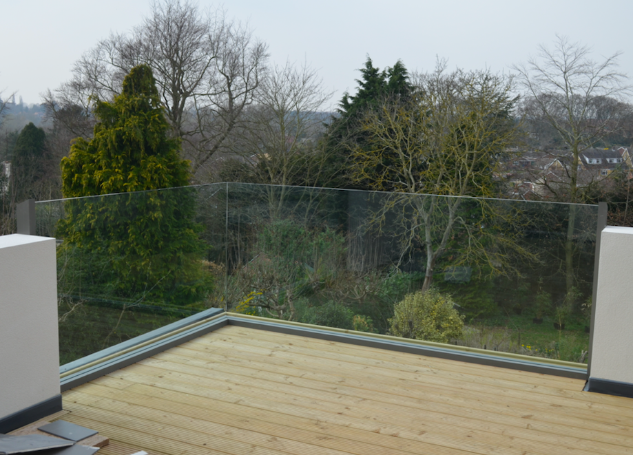 frameless glass balcony overlooking forest and greenery