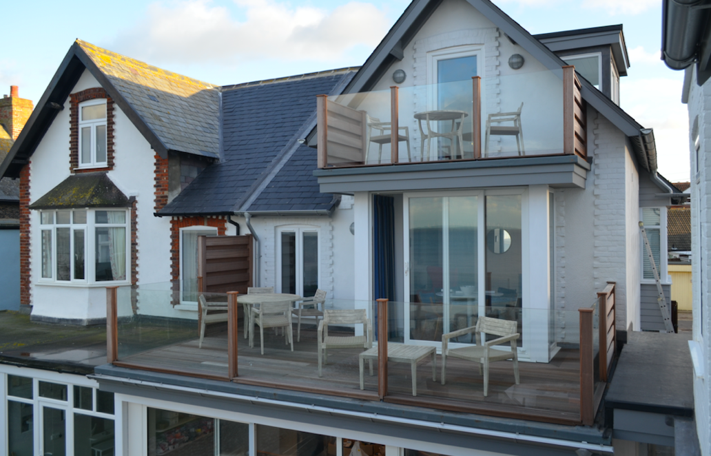 double storey glass balcony and balustrade on the front of coastal home