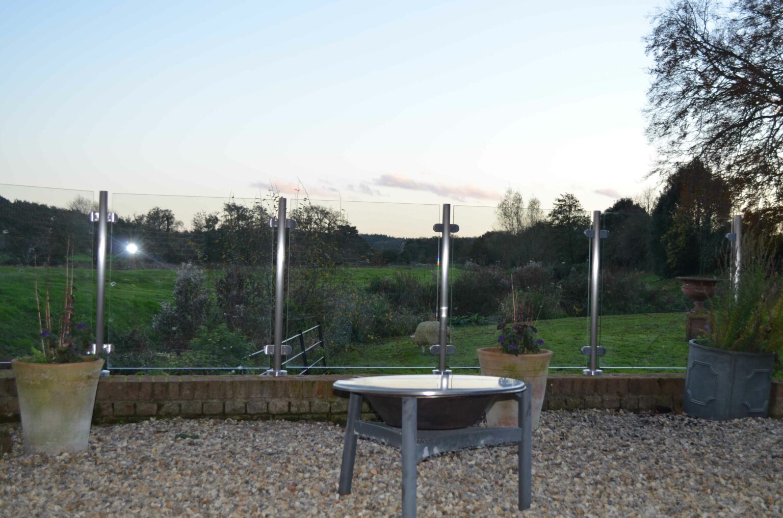 unobstructed view of back garden and fields beyond because of clamped glass balustrade installed