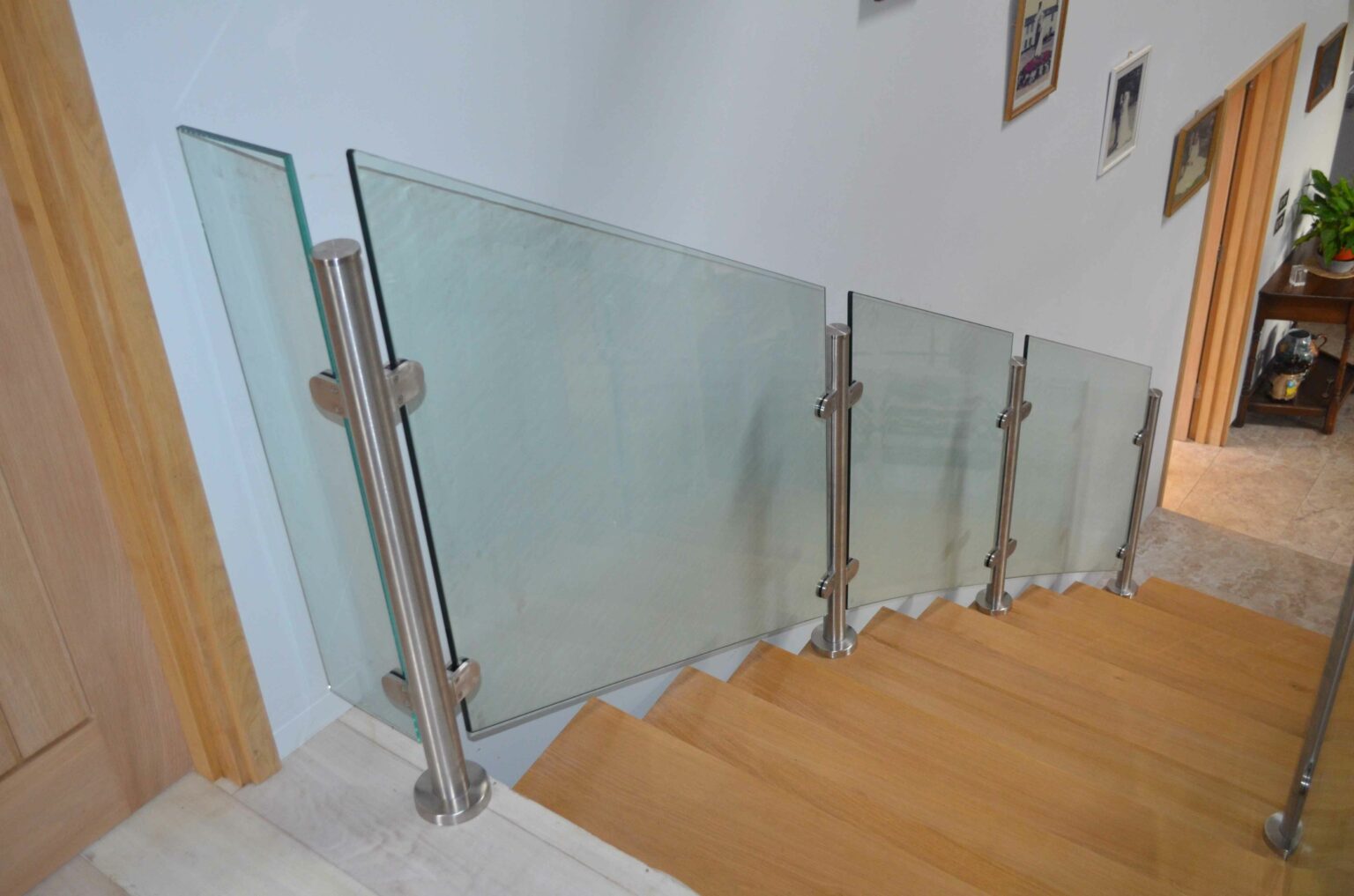 glass panel and metal post wooden staircase in hallway