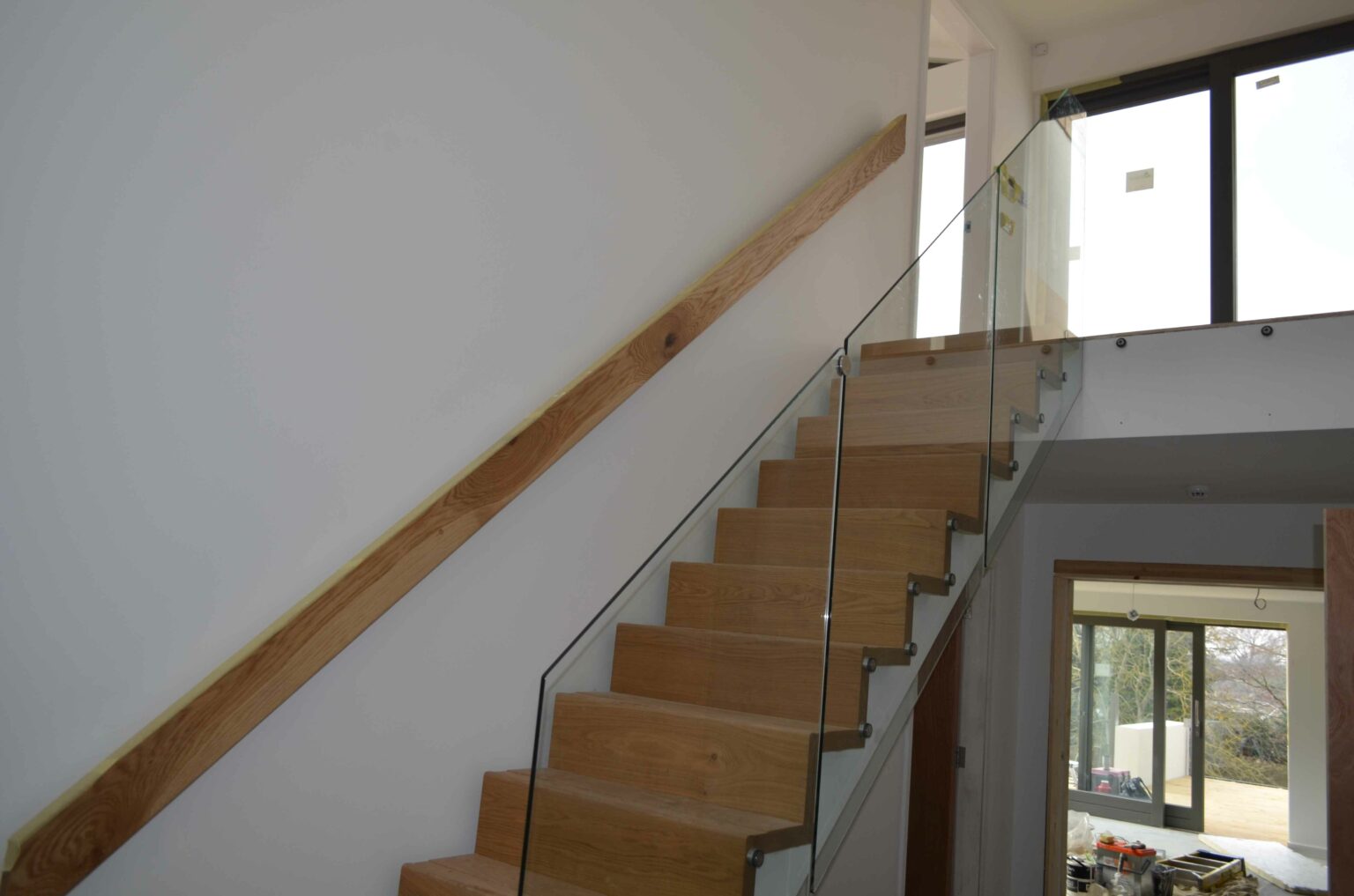 airy and light landing and hallway with glass staircase and balustrade installation