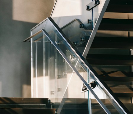 glass wraparound staircase with metal bannister in commercial building