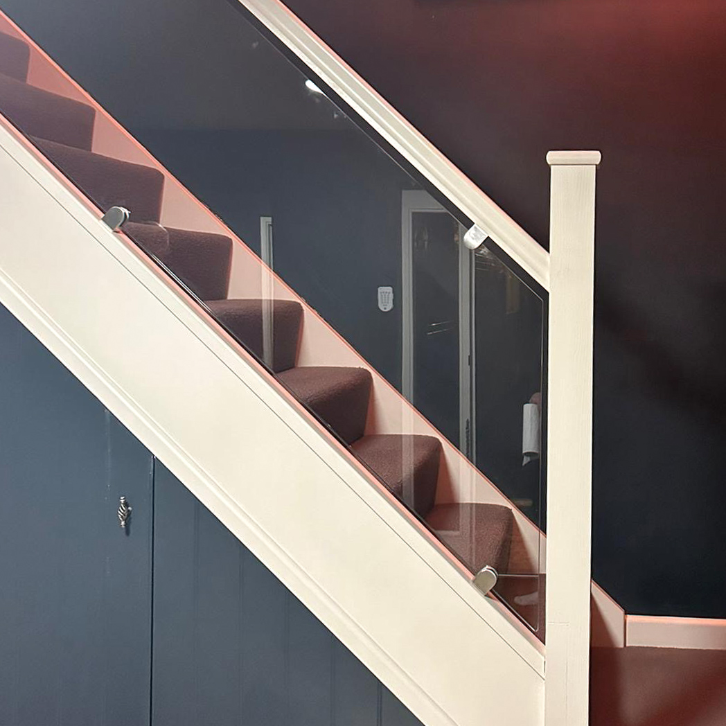 contemporary staircase with black painted walls a glass staircase and a neon sign