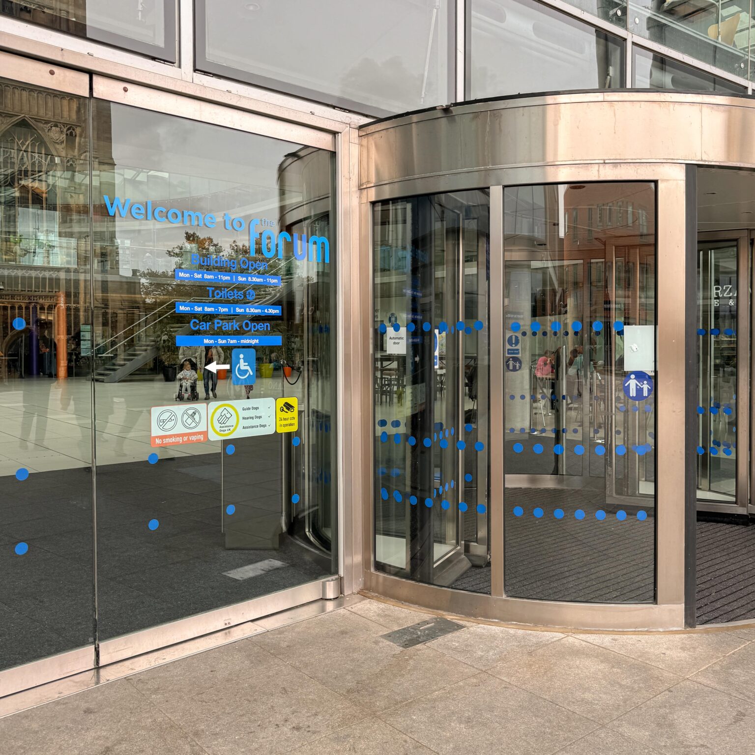 glass windows and rotating door at the front of The Forum