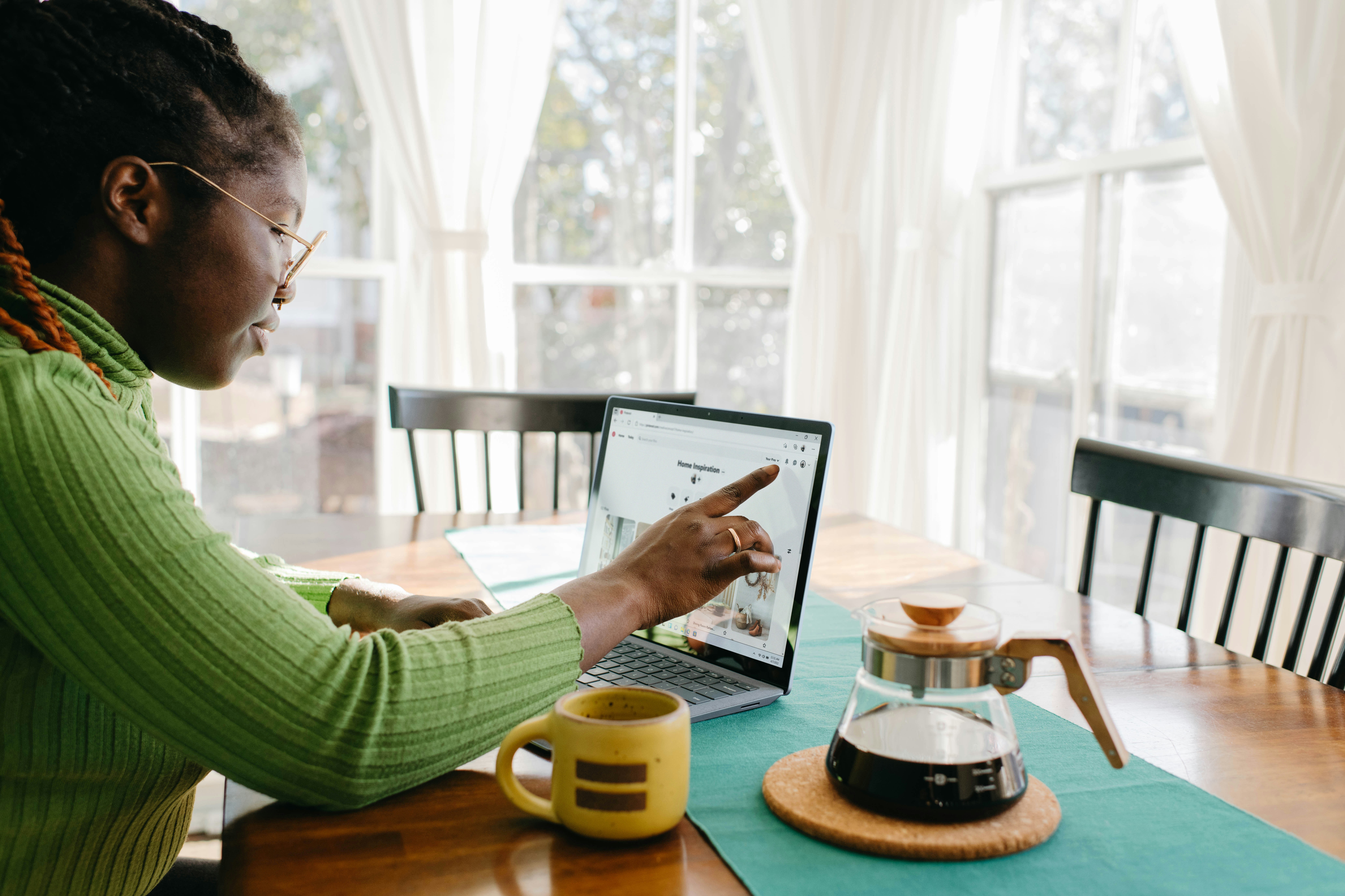 Woman working on laptop in front of windows