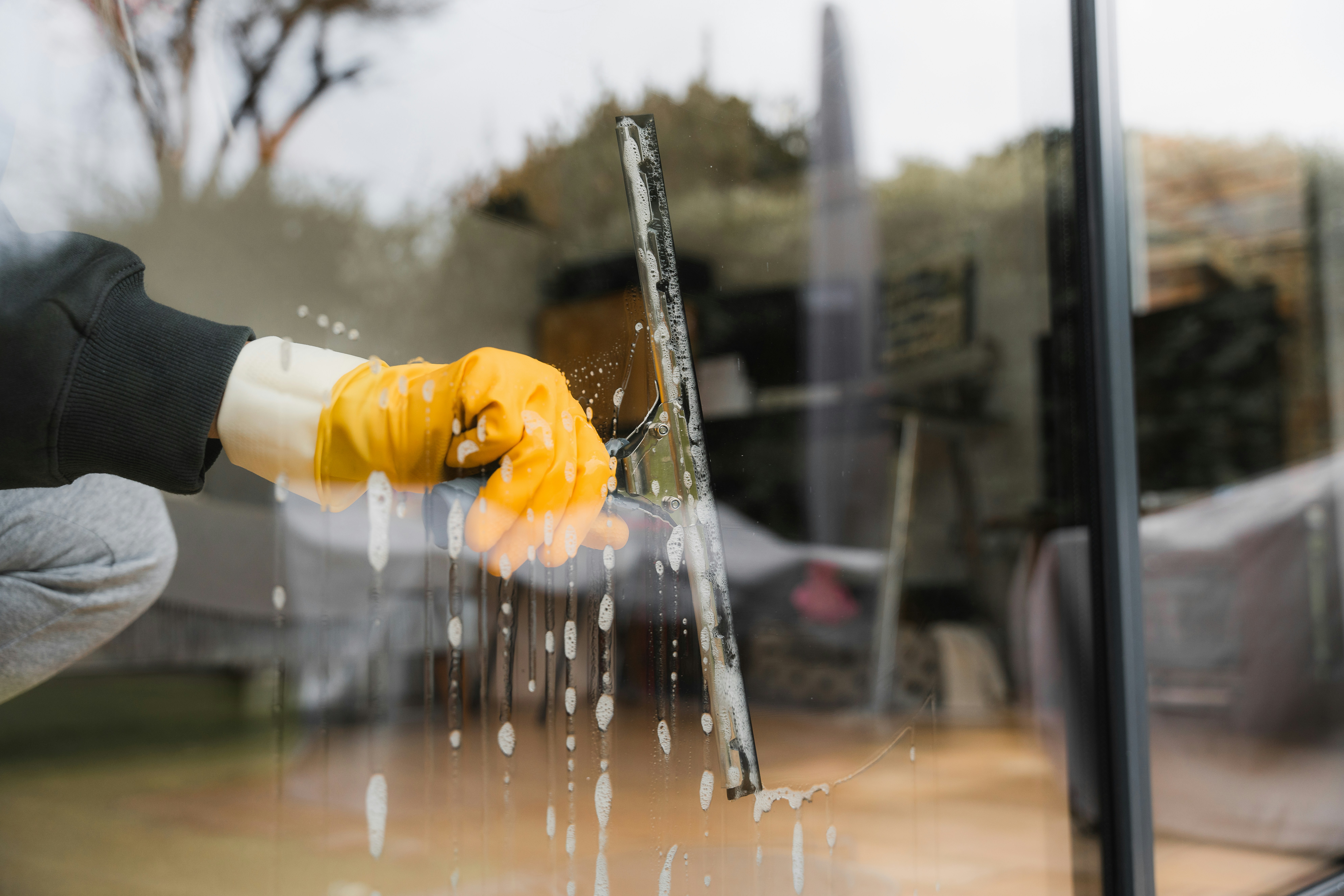 Close up of person washing a window with a squeedgee